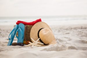 Bag and beach accessories kept on sand at beach